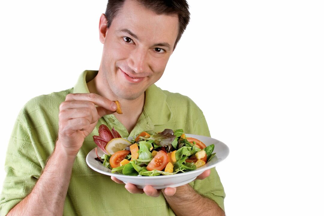 男は効力のために野菜サラダを食べる
